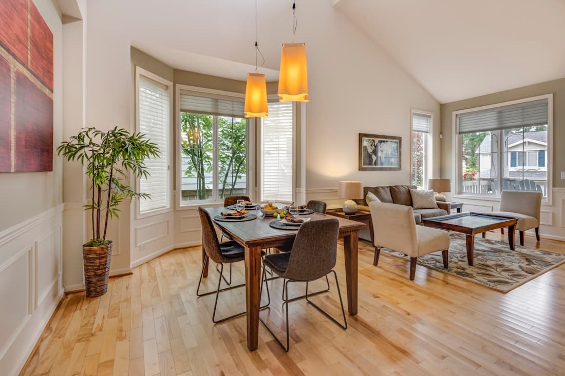 Dining area with hardwood floors and bay windows in an empty apartment