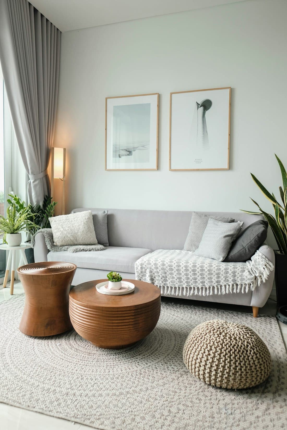 Living room with a light sofa, plants and daylight from a large window